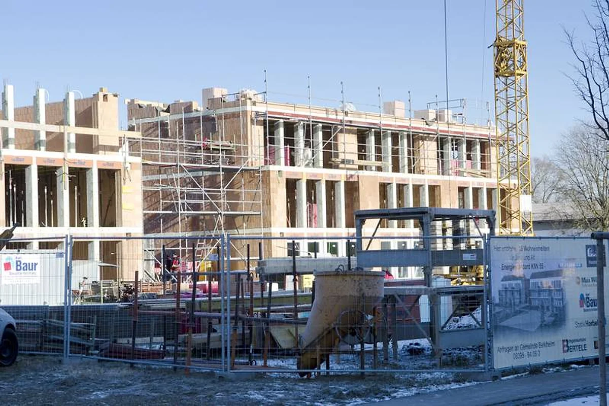 Mehrgeschossiger Rohbau mit Gerüst und Baur-Baustellenabsperrung